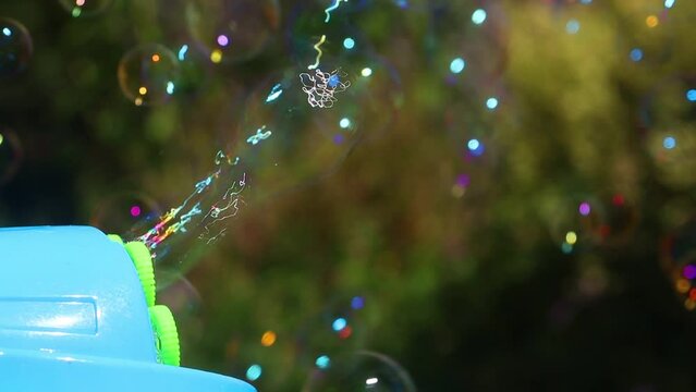 The automatic bubble blower make soap bubbles in the summer garden