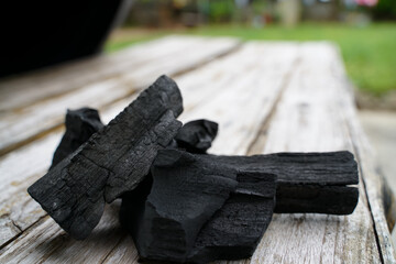 Black charcoal on old wood background, Charcoal is essential in grilling.