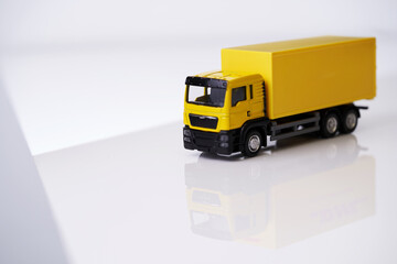 yellow toy cargo truck against white background