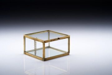 closed glass jewerly box on white to gray background