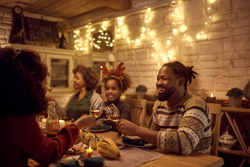 Fototapeta na wymiar Happy black family toasting during Thanksgiving dinner at dining table.