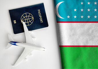 Flag of Uzbekistan with passport and toy airplane. Flight travel concept

