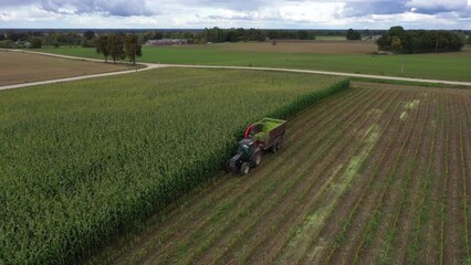 Biomass production with tractor using forage harvester chopping corn into silage
