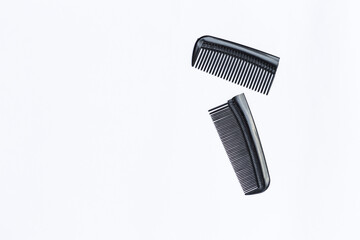 Broken black plastic comb with space on white background, low quality plastic comb