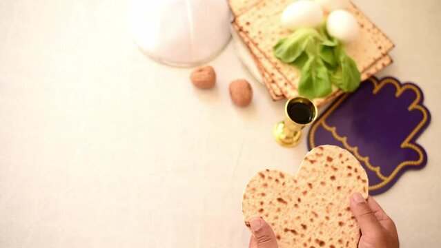 Man's hands holds Matzah shape of heart. Traditional of Jewish Holiday on Passover. Home symbol of lovely family. top view, layout. love and care. Space for text.