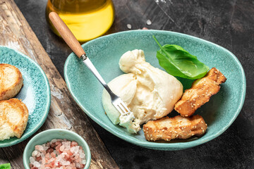 Burrata cheese with Basil leaves on white plate on dark background. banner, menu, recipe place for text, top view