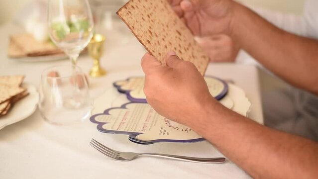 Man read book for pesah. Holiday of Jewish people, matzo national food served on table on white plate. Traditionally prepared for Passover with red wine. 