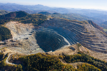 Flying above an open pit mine, copper excavation in Rosia Poieni, Romania. Aerial view