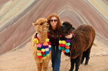 Washable wall murals Vinicunca Young red haired girl with two cute alpacas at Vinicunca Rainbow Mountain, Peru