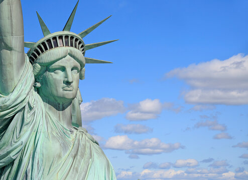 Head and bust of Statue of Liberty with blue sky and clouds on the background, New York City, USA