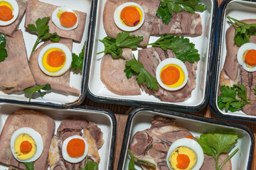 Ingredients for jellied tongue are arranging in rectangular enamel molds.