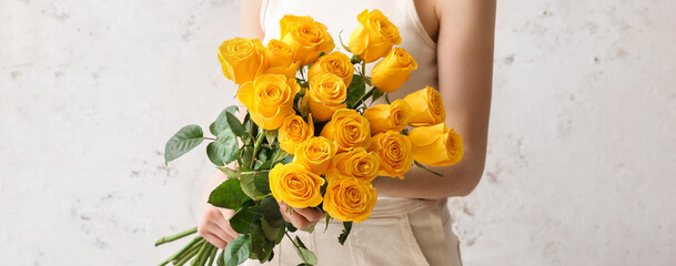 Young woman with bouquet of beautiful yellow roses on light background, closeup - Powered by Adobe