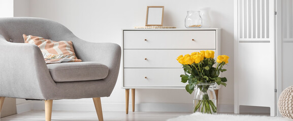 Vase with beautiful yellow roses in interior of living room