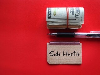 Cash dollars money and pen writing on stick note SIDE HUSTLE, concept of making more income from...