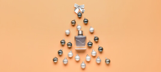 Christmas tree made of perfume bottle and balls on orange background