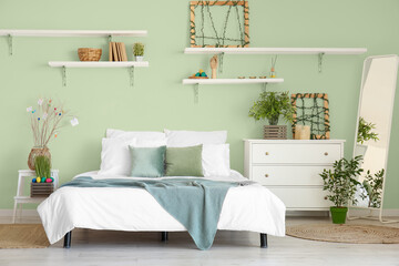 Interior of light bedroom with green wall decorated for Easter