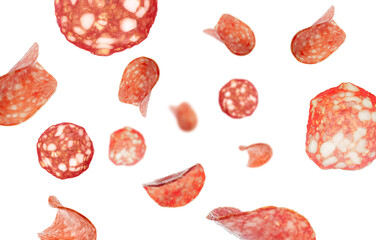 Many flying slices of delicious salami isolated on white