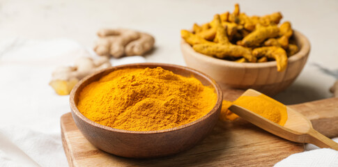 Bowl and scoop with turmeric powder on table