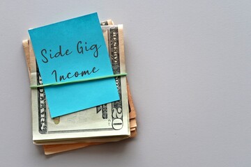 Dollars cash money with handwritten note SIDE GIG INCOME on white background - concept of financial planning - make more extra money from part time side hustle , second job or side gig to boost income