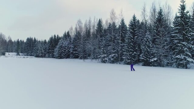 Person cross country skiing through a winter wonderland with snow capped forest