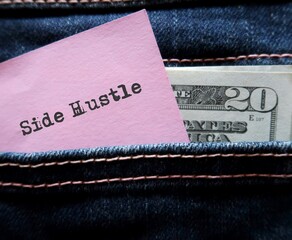 Cash dollars money and pink note with hand written text SIDE HUSTLE in jeans pocket , concept of...