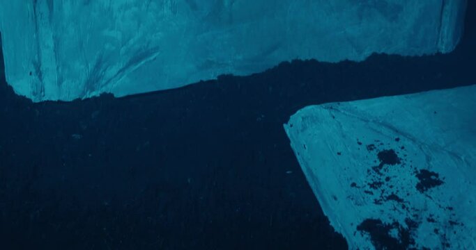 Zombie hand from the grave slowly gropes at a fallen tombstone.