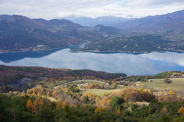 panoramic view of the mirror reflection of the mountains and clouds on a fall day in Serre Ponçon...