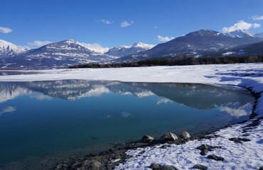 Fototapeta na wymiar mirror reflection of the mountains in winter at Serre Ponçon lake in the Southern Alps, France 