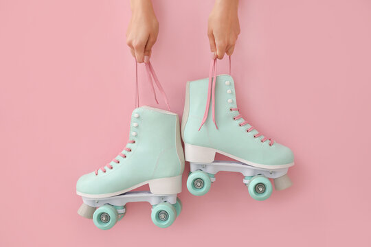 Woman Holding Vintage Roller Skates On Color Background