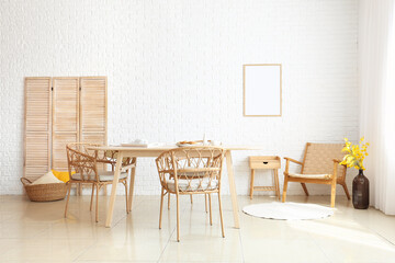 Interior of dining room with modern furniture near white brick wall