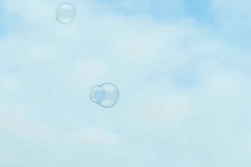 Beautiful soap bubbles on blue sky background