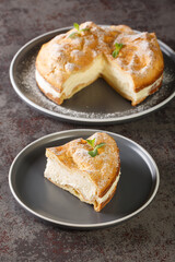 Traditional Polish cake Karpatka of choux pastry dough and custard cream closeup on the plate on the table. Vertical