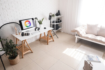 Interior of modern office with photographer's workplace, equipment and couch