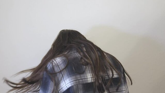 A Hispanic female flips her hair twice and smiles. Shot in 4k 60fps for high quality slow motion.