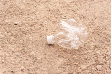 a small crushed water bottle on the ground