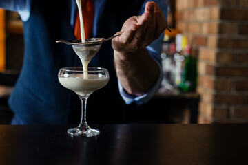 Man bartender pouring alcohol in glass