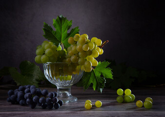Still life with a bunch of green, red grapes and grape leaves © 02irina