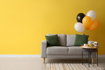 Interior of stylish living room with sofa and Halloween balloons