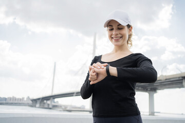 A woman is using a fitness bracelet watch app on her arm.