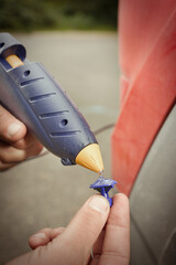 Car owner working on a dent repair with reverse hammer and glue