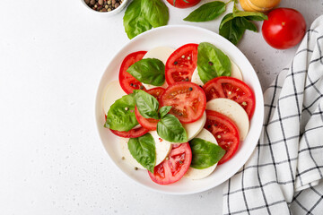 Caprese salad made of sliced fresh tomatoes, mozzarella cheese and basil.