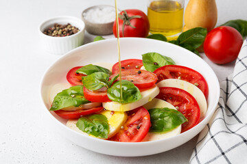 Caprese Salad with tomatoes and mozzarella with olive oil.
