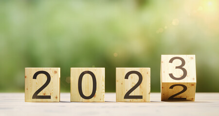2022 change to 2023 concept wood box flipping on blur background copy space. sign in celebration of the new year 2023	