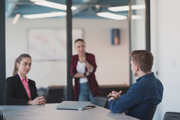 Collaborative process of multicultural skilled young business team during brainstorming meeting in office.Diverse group of young people dressed in formal wear cooperating on developing design project