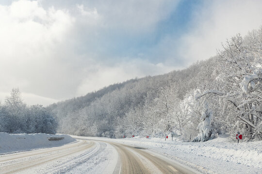 Scenic view of curve turn on beautiful mountain forest cpuntry woods highway road at cold snowy sunny weather winter day. Wintry frosty route landcape. Travel season journey trip drive