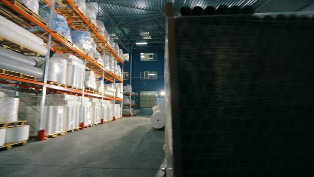 Large warehouse in a nonwovens factory. Large modern warehouse in the factory. Industrial interior. Lots of big rolls of spunbond. Warehouse with rolls of nonwovens.