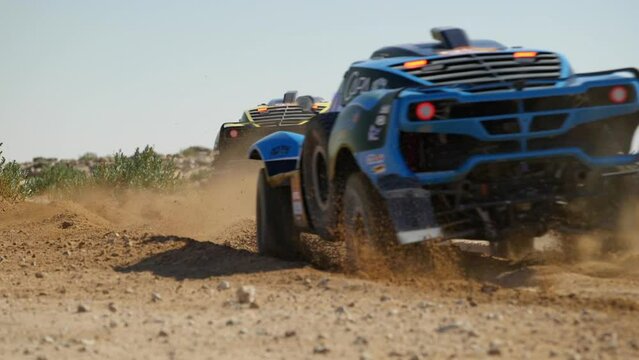 Dakar Rally Cars Racing On The Dusty Curve Of Desert. - wide