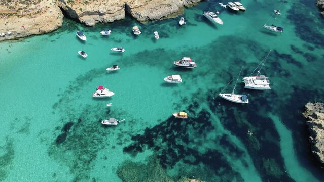 Boats in Blue Lagoon, Malta, rising aerial view