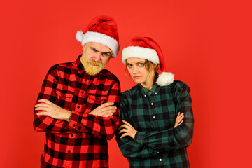 Fototapeta premium Winter entertainment. Santa Claus style. Having fun. Christmas time. Wear Santa hat. Man and woman christmas holiday celebration. Christmas party. Couple in love new year eve. Simple happiness