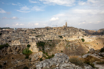 Fototapeta premium Panoramic view of Sassi di Matera a historic district in the city of Matera, well-known for their ancient cave dwellings from the Belvedere di Murgia Timone, Basilicata, Italy